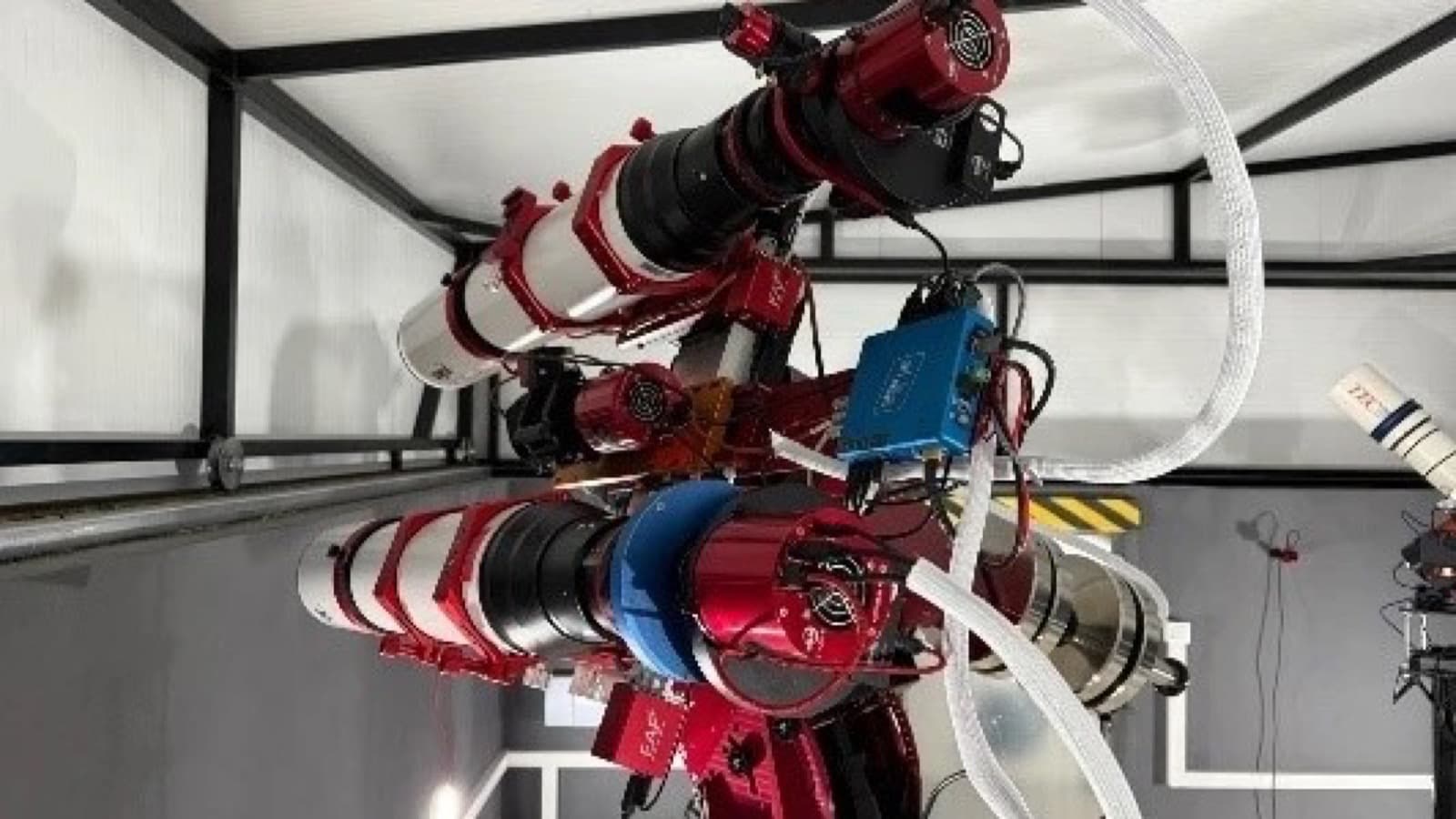 The twin FF130 rig mounted side by side in the Spanish observatory, showing the two white tubes with red rings, filter wheels, rotators and cable runs